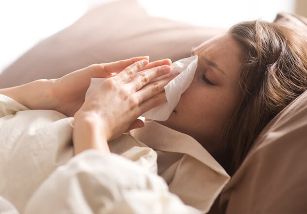 Frau mit Schnupfen & Erkältung: Zinkmangel kann ein Grund sein